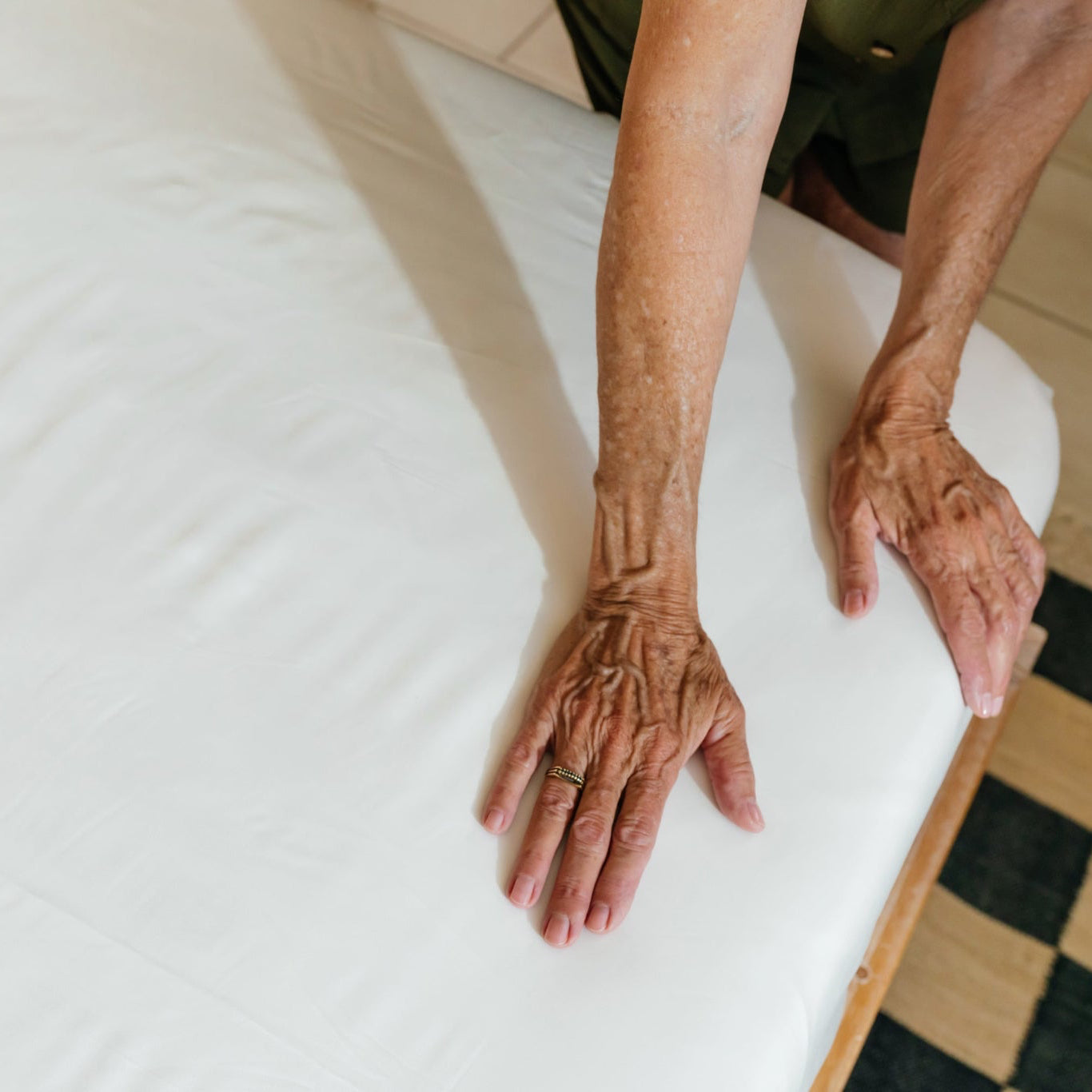 old woman hands on sateen fabric