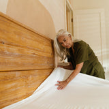older woman making bed